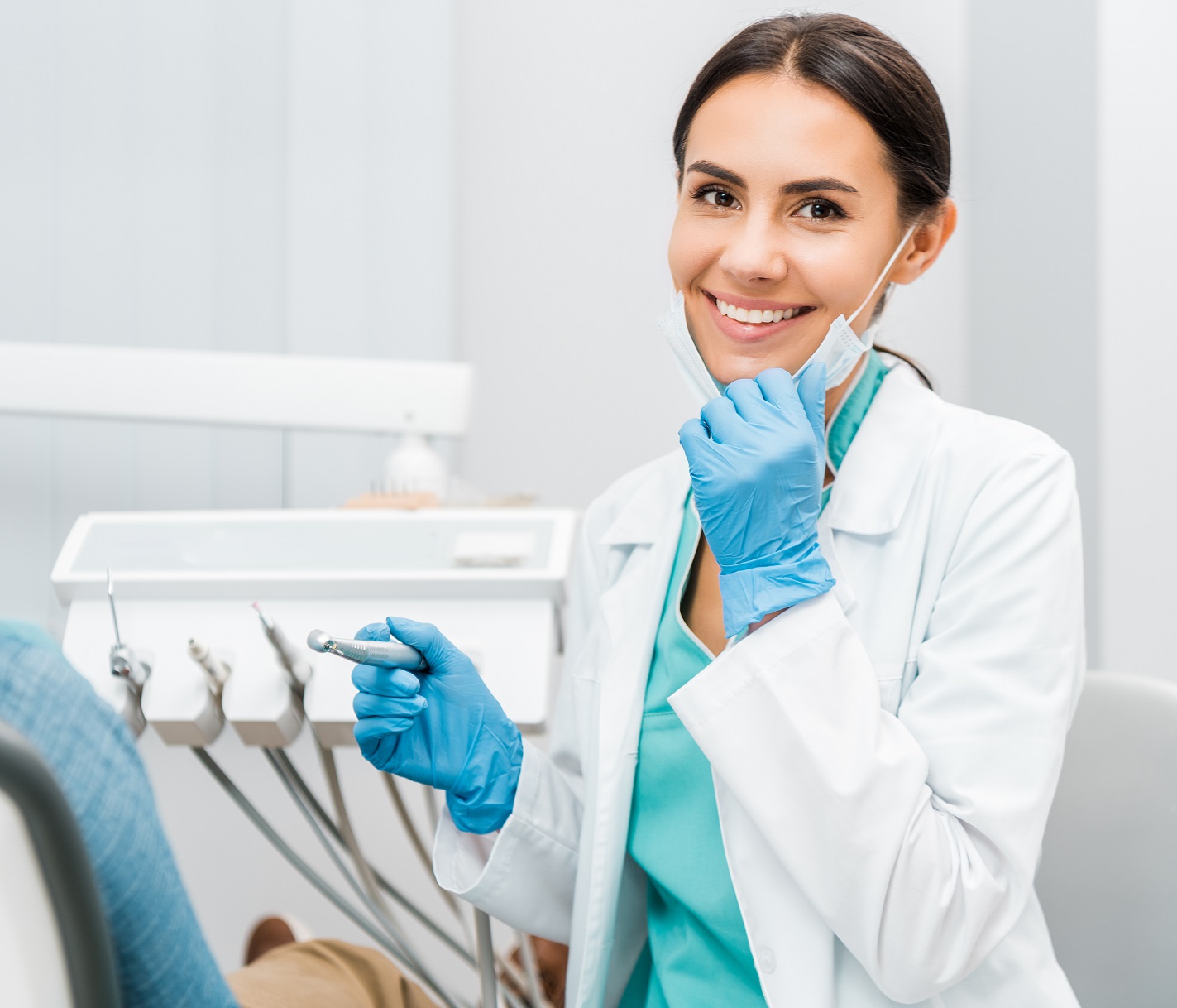 Cheerful Female Dentist Holding Drill And Smiling Near Patient