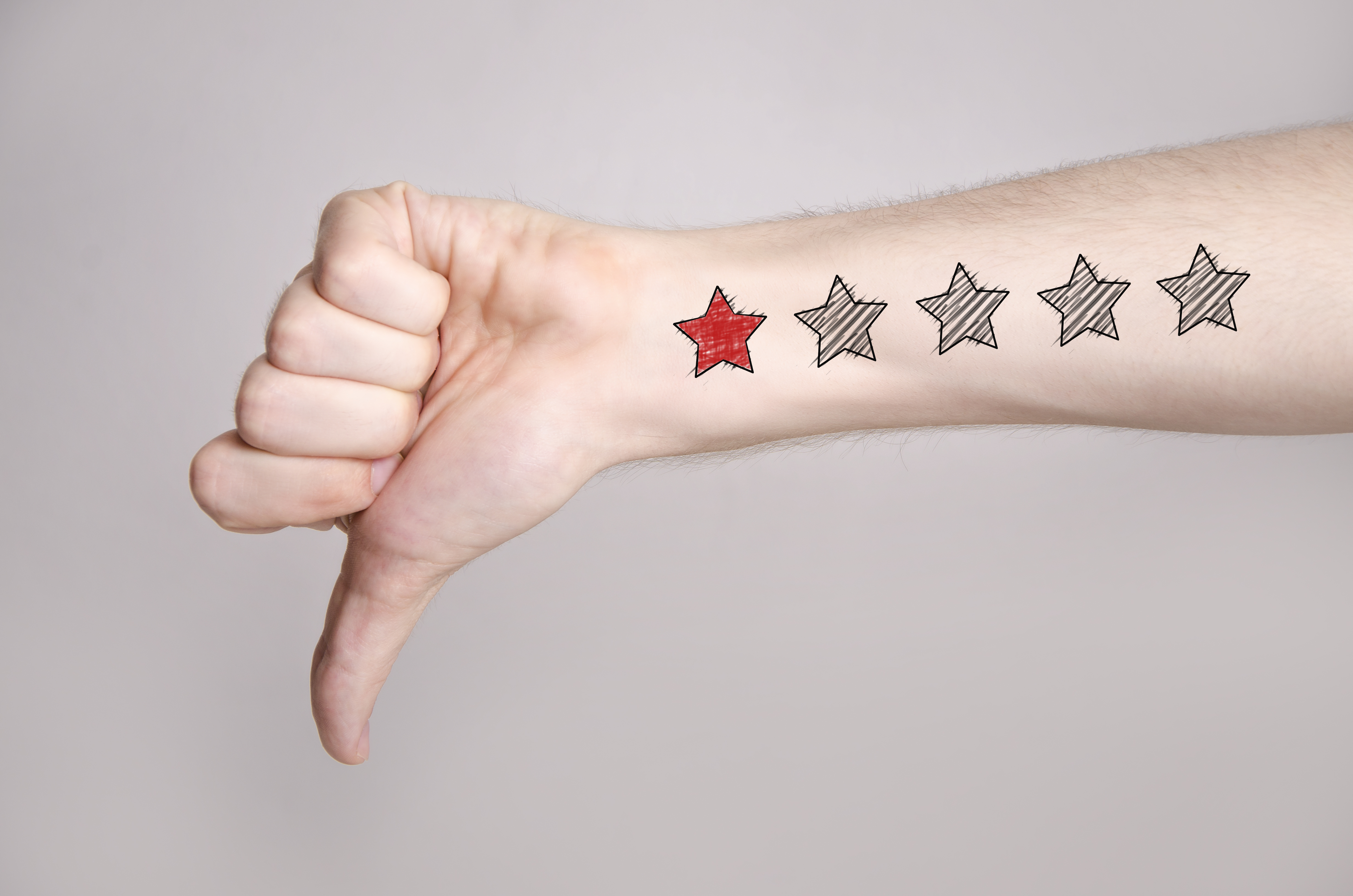 Man,Hand,Showing,Thumbs,Down,And,One,Star,Rating,On