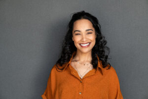 closeup of a smiling woman against a grey background